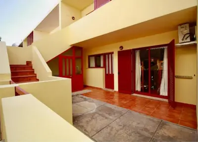 an empty room with red doors and a staircase at Angela Beach Place in Vila Baleira