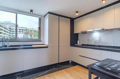 a kitchen with white cabinets and a window at GuestReady - The place to be happy in Madeira in Funchal
