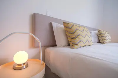 a bedroom with a bed with a lamp on a table at GuestReady - The place to be happy in Madeira in Funchal