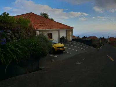 a yellow car parked in front of a house at Horizon Retreat in Calheta