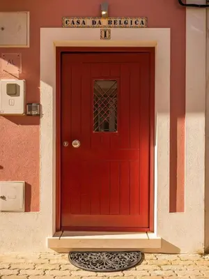 a red door on the side of a building at Casa Da Bélgica in Sagres