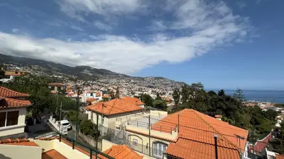 a view of a city with houses and the ocean at Casa Santiago II Funchal in Funchal