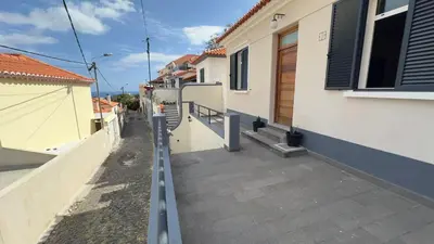 a walkway between two buildings with a house at Casa Santiago II Funchal in Funchal