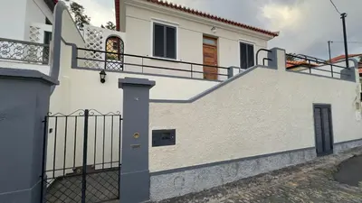 a white house with a gate and stairs at Casa Santiago II Funchal in Funchal