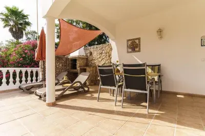 a patio with chairs and a table and a fireplace at Villa Fillmare in Lagos