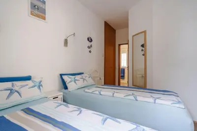 a bedroom with two beds and a mirror at Villa Fillmare in Lagos
