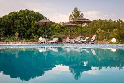a swimming pool with chairs and umbrellas at Villa Fillmare in Lagos