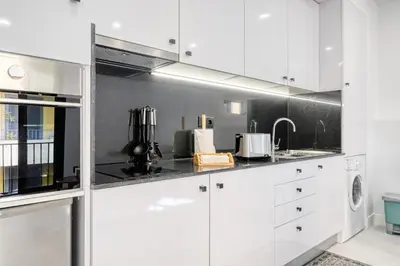 a white kitchen with white cabinets and a sink at Beco Santa Emilia 2I, a Home in Madeira in Funchal