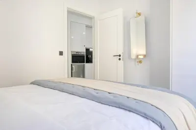 a white room with a bed with a oven in it at Beco Santa Emilia 2I, a Home in Madeira in Funchal