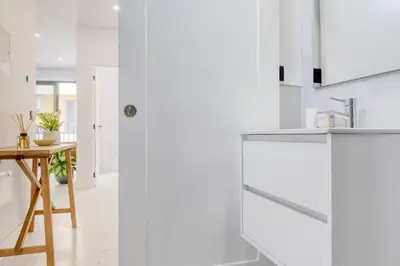 a kitchen with white cabinets and a wooden table at Beco Santa Emilia 2I, a Home in Madeira in Funchal