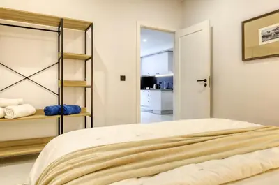 a bedroom with a bed and a kitchen at Beco Santa Emilia 2G, a Home in Madeira in Funchal