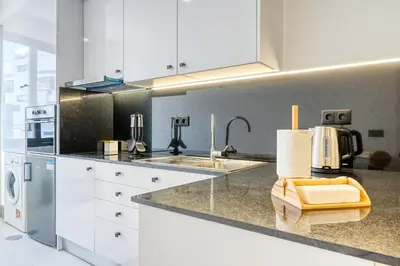 a kitchen with white cabinets and a sink at Beco Santa Emilia 2G, a Home in Madeira in Funchal