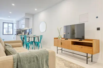 a living room with a tv and a table with chairs at Beco Santa Emilia 2G, a Home in Madeira in Funchal
