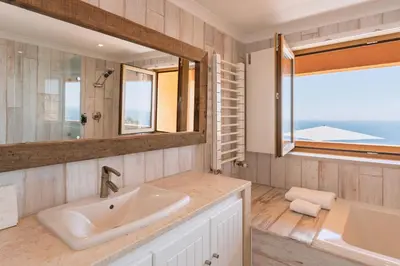 a bedroom with a sliding glass door with a television at Casa Pôr do Sal in Luz