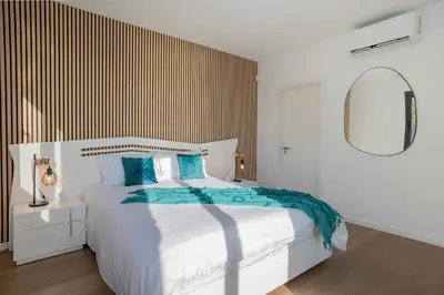 a bedroom with a white bed and a mirror at Villa Luxe by Atlantic Holiday in Ribeira Brava