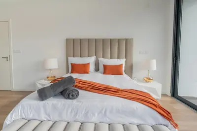 a bedroom with a large bed with orange pillows at Villa Luxe by Atlantic Holiday in Ribeira Brava