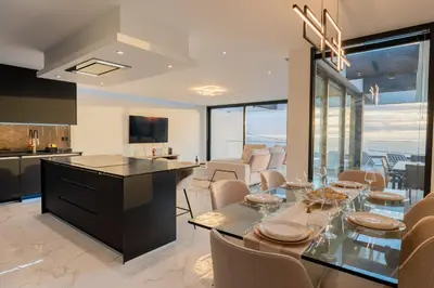 a kitchen and living room with a table and chairs at Villa Luxe by Atlantic Holiday in Ribeira Brava