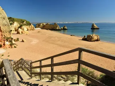 a beach with a wooden fence and the ocean at Flat in Praia da Luz with Sea Views in Luz