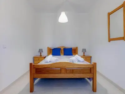 a kitchen with a table and a white refrigerator at Casa Teresinha with private pool in Montinhos da Luz