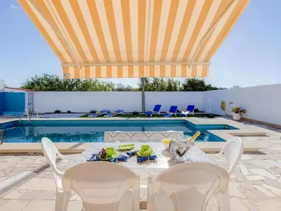 a pile of towels sitting on a blue table next to a pool at Casa Teresinha with private pool in Montinhos da Luz