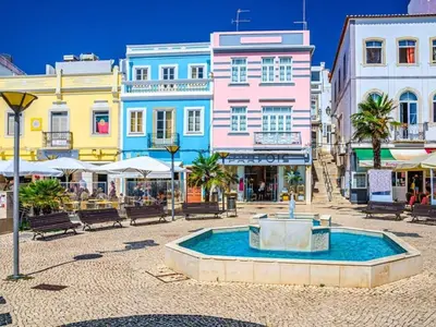 a city square with a fountain in front of buildings at Casa Teresinha with private pool in Montinhos da Luz