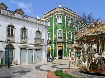 a large green building with a carousel in front of it at Casa Teresinha with private pool in Montinhos da Luz