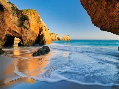 a beach with some rocks in the water at Casa Teresinha with private pool in Montinhos da Luz