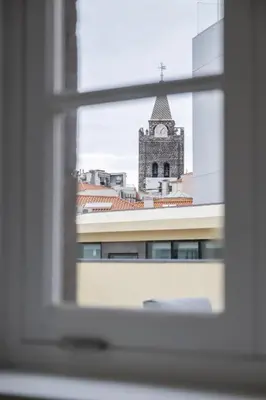 a view of a clock tower from a window at Studios Funchal in Funchal