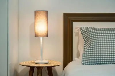 a lamp on a table next to a bed at Studios Funchal in Funchal