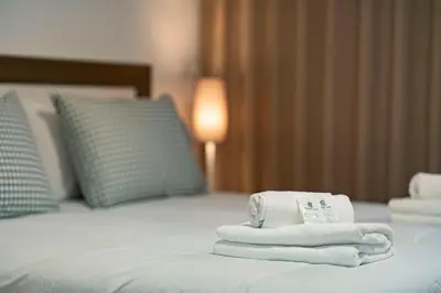 a pile of towels sitting on top of a bed at Studios Funchal in Funchal