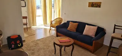 a living room with a blue couch and a table at Apartamento renovado e luminoso a poucos minutos do centro in Funchal