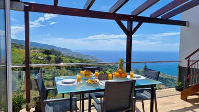 a table with fruit on it on the balcony of a house at Valley Miradouro View by LovelyStay in Ponta do Sol