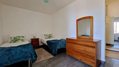 a bedroom with two beds and a dresser and a mirror at Valley Miradouro View by LovelyStay in Ponta do Sol