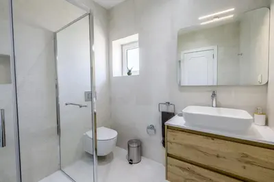 a bathroom with a sink and a toilet and a mirror at The Look-Out Sagres in Sagres