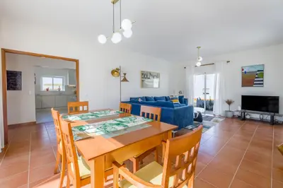 a dining room and living room with a table and chairs at Sunny Sagres in Sagres