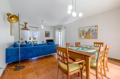 a living room with a table and a blue couch at Sunny Sagres in Sagres