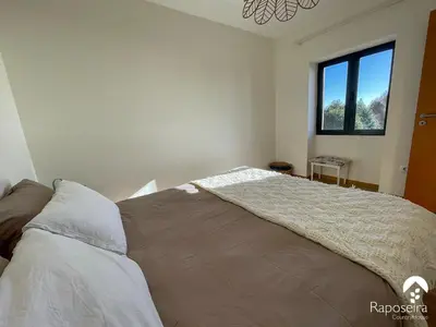 a bedroom with a bed with a blanket on it at Raposeira Country House in Calheta