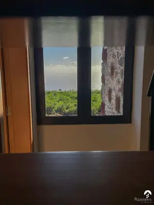 a window in a room with a view of the ocean at Raposeira Country House in Calheta