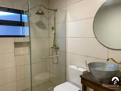 a bathroom with a shower and a sink and a toilet at Raposeira Country House in Calheta