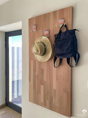 a hat and a bag hanging on a wall at Raposeira Country House in Calheta