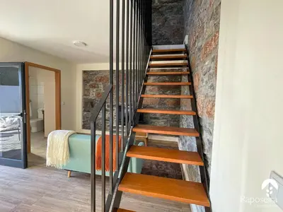 a staircase in a room with a brick wall at Raposeira Country House in Calheta