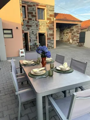 a table with plates and napkins on a patio at Raposeira Country House in Calheta