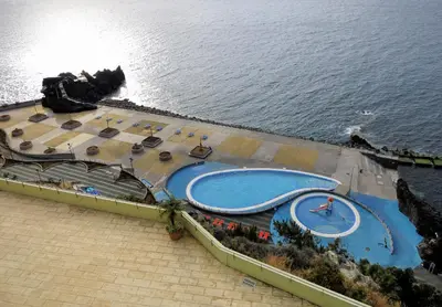 a white fence with the ocean in the background at Superior Rentals - Beachfront Penthouse in Funchal
