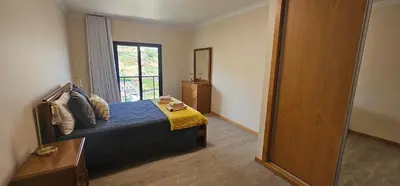 a bedroom with a bed and a large window at Peaceful Valley house in Câmara de Lobos