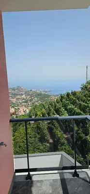 a balcony of a building with a view of the ocean at Peaceful Valley house in Câmara de Lobos