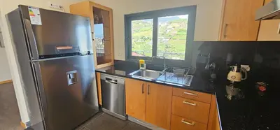 a kitchen with a stainless steel refrigerator and a sink at Peaceful Valley house in Câmara de Lobos