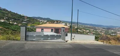 a house with a gate on the side of a road at Peaceful Valley house in Câmara de Lobos