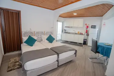a kitchen with wooden cabinets and a white refrigerator at Sunset Star II With Sea View in Calheta