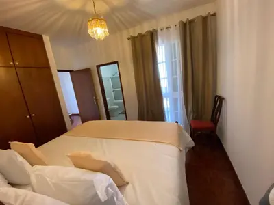 a bedroom with a white bed and a mirror at Casa a Torre in Santa Cruz