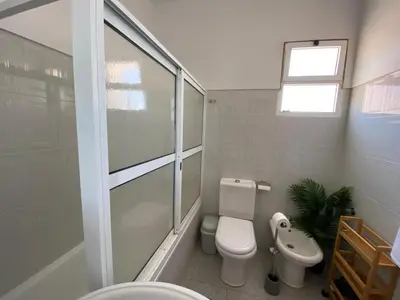 a white bathroom with a toilet and a sink at Casa a Torre in Santa Cruz